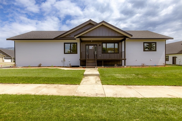 57 Hidden Cedar Loop, Columbia Falls, MT 59912 - view of front facade with a porch, a front yard, a shingled roof, and board and batten siding