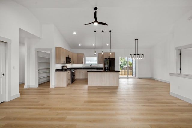57 Hidden Cedar Loop, Columbia Falls, MT 59912 - kitchen featuring light brown cabinets, stainless steel fridge, range with gas cooktop, black microwave, and open floor plan