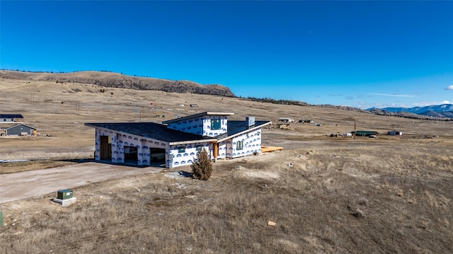 view of front of property with a mountain view and driveway