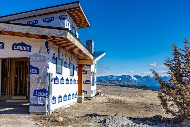 view of side of home featuring a mountain view and a chimney