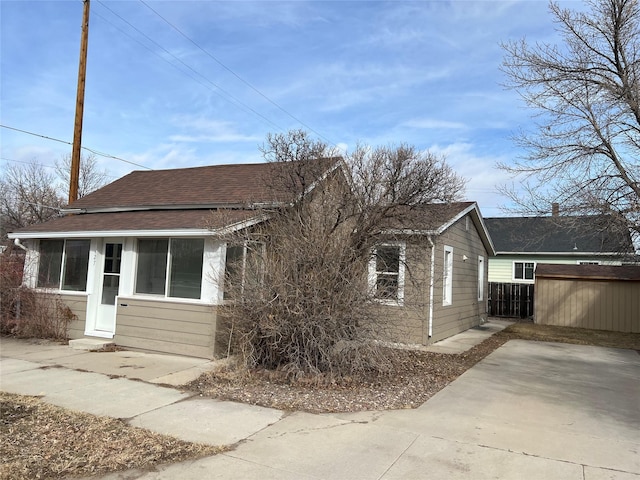 view of property exterior with a shingled roof