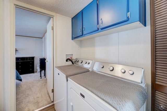 laundry area with washing machine and clothes dryer, cabinet space, a textured ceiling, and light colored carpet