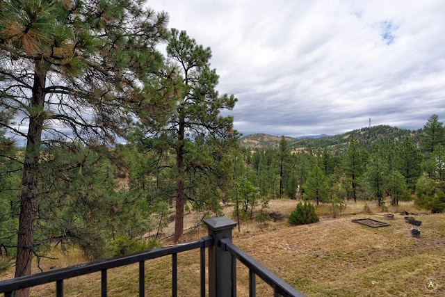 view of yard featuring a mountain view and a wooded view