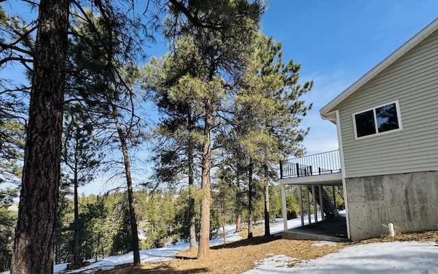 6520 Canyon Ferry Rd, Helena, MT 59602 - snowy yard with stairs, a wooden deck, and a carport