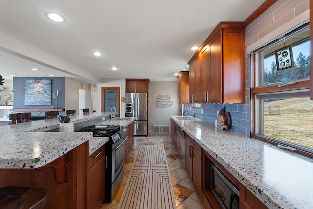 kitchen featuring light stone countertops, visible vents, recessed lighting, appliances with stainless steel finishes, and tasteful backsplash