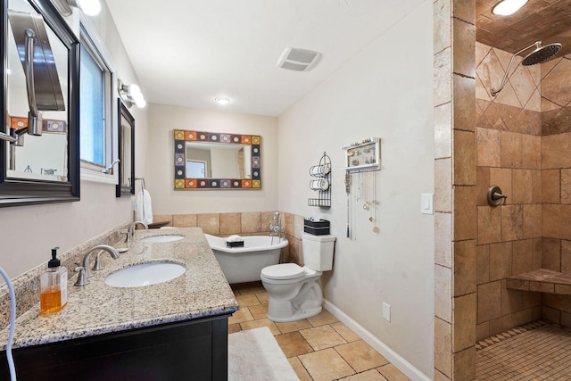 bathroom with a sink, a freestanding tub, tiled shower, and baseboards