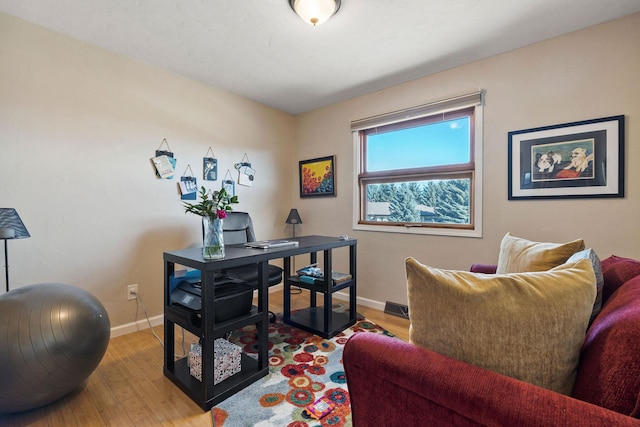 office area featuring visible vents, wood finished floors, and baseboards