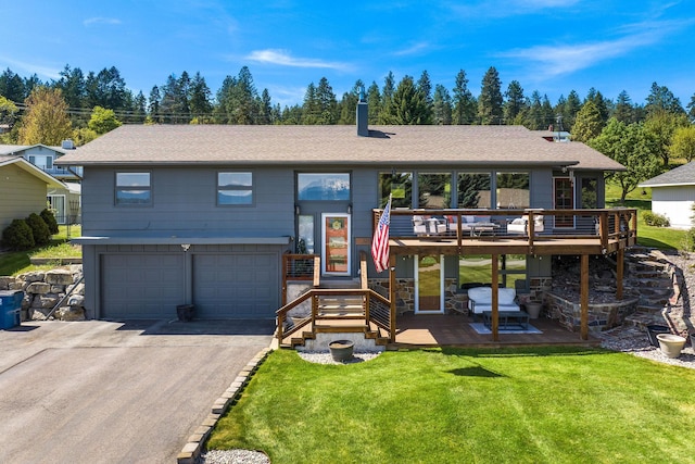 128 Sunset Rdg, Lakeside, MT 59922 - view of front of property with an attached garage, driveway, a front lawn, a wooden deck, and roof with shingles