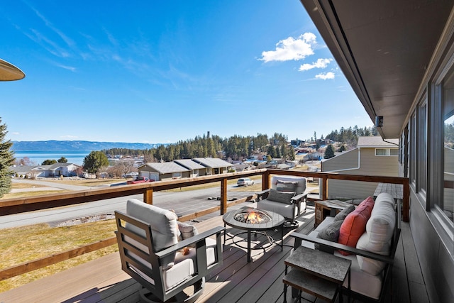 wooden deck featuring a mountain view and a fire pit