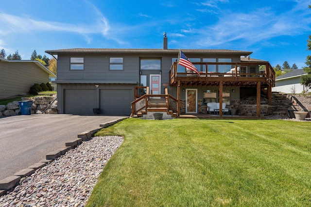 128 Sunset Rdg, Lakeside, MT 59922 - rear view of house with an attached garage, a yard, a wooden deck, and asphalt driveway