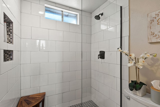 bathroom featuring toilet and tiled shower