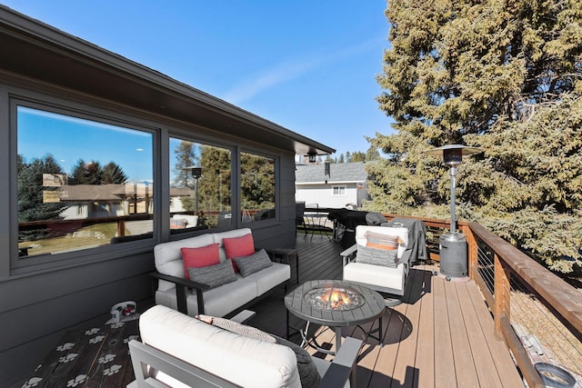 wooden deck featuring an outdoor living space with a fire pit