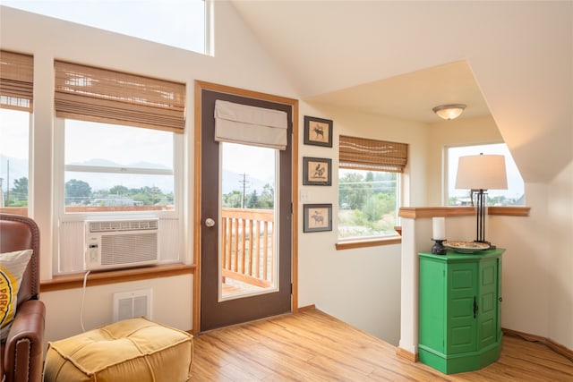 entryway with vaulted ceiling, visible vents, baseboards, and wood finished floors