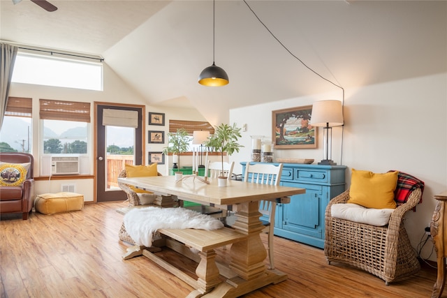 dining room featuring cooling unit, high vaulted ceiling, and light wood-style floors