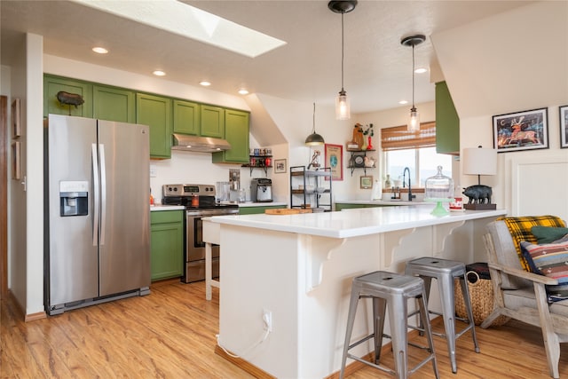 kitchen with under cabinet range hood, light wood-style flooring, appliances with stainless steel finishes, and green cabinets