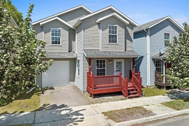 view of front of property featuring driveway, an attached garage, and a shingled roof