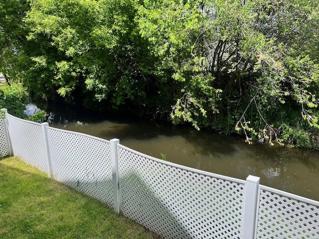 exterior space featuring a water view and fence