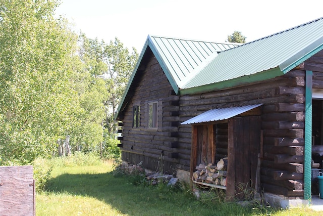 view of side of property featuring log siding and metal roof