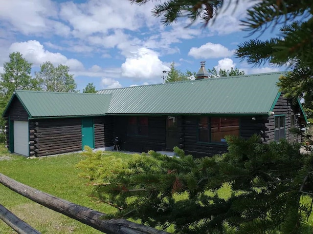 exterior space featuring a front lawn, log siding, and metal roof