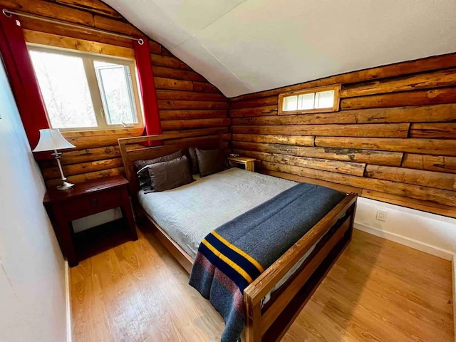 bedroom featuring rustic walls, lofted ceiling, and wood finished floors