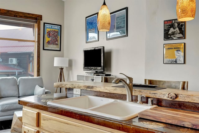 kitchen featuring decorative light fixtures, open floor plan, and a sink