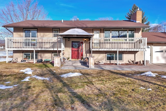 view of front of home with a front lawn, a balcony, an attached garage, and a chimney