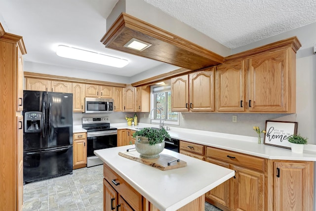 kitchen featuring black appliances, a sink, a kitchen island, a textured ceiling, and light countertops