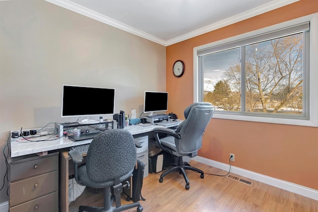 home office featuring visible vents, light wood-type flooring, baseboards, and ornamental molding