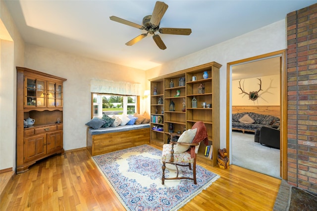 living area featuring light wood-type flooring and a ceiling fan