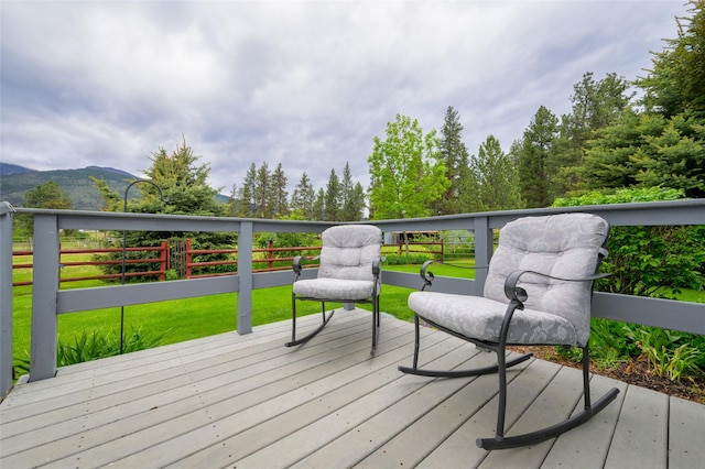 wooden deck with a yard and a mountain view