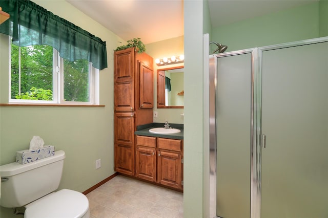 full bath with vanity, baseboards, a stall shower, tile patterned floors, and toilet