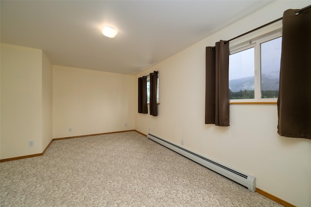 empty room with a baseboard heating unit, a mountain view, baseboards, and carpet floors