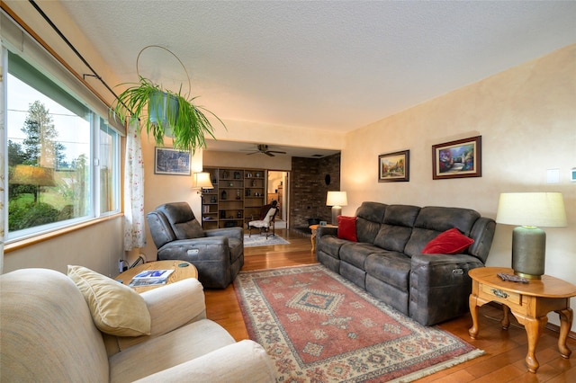 living area featuring ceiling fan, a textured ceiling, and wood finished floors