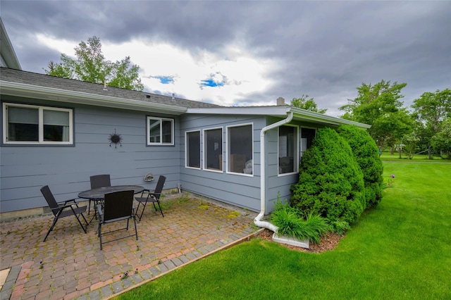 back of house with a patio area and a lawn