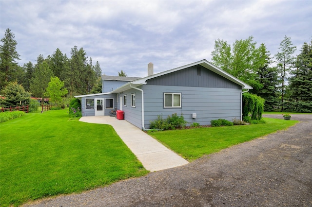 5400 Two Moons Rd, Florence, MT 59833 - view of front of house featuring a chimney, a front lawn, and a patio area