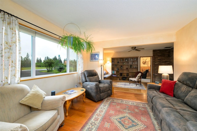 living area with hardwood / wood-style floors and a ceiling fan