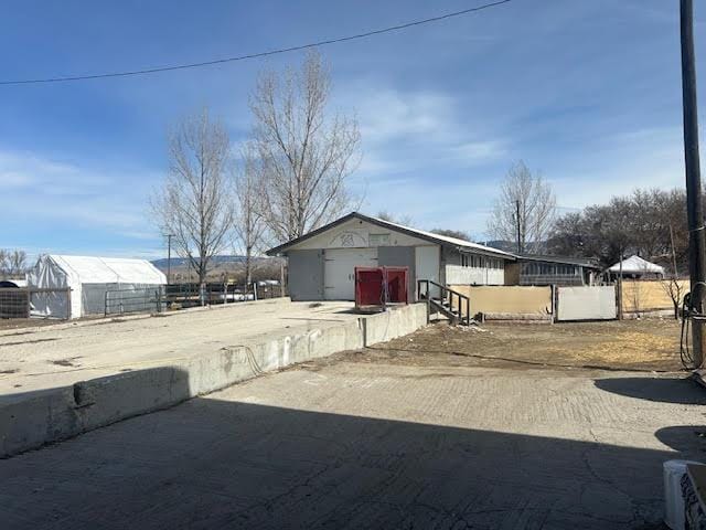 view of side of home with an outbuilding and fence