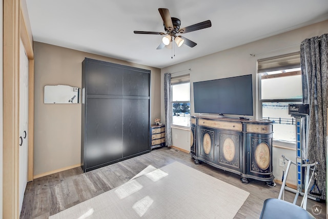 bedroom with baseboards, wood finished floors, and a ceiling fan