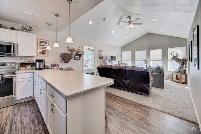 kitchen with a ceiling fan, a peninsula, stainless steel appliances, light countertops, and white cabinets