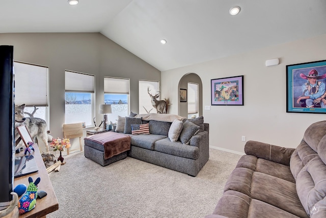 carpeted living room with recessed lighting, baseboards, arched walkways, and high vaulted ceiling