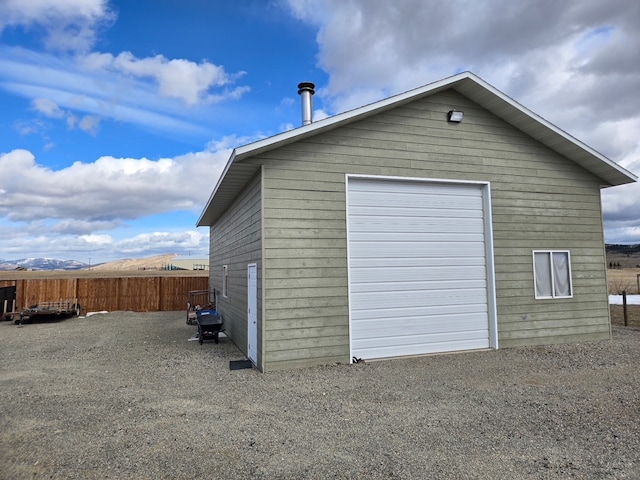 detached garage featuring fence and a mountain view