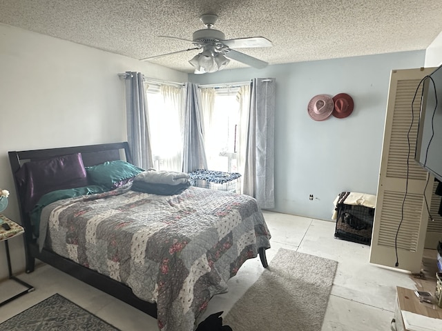 bedroom with a ceiling fan and a textured ceiling