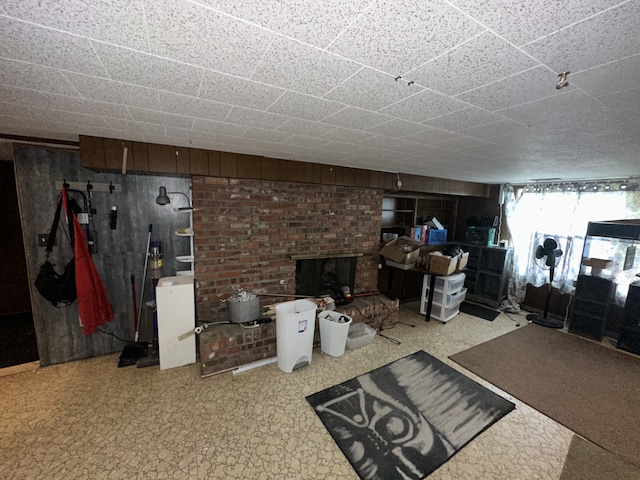 below grade area featuring a brick fireplace and wood walls