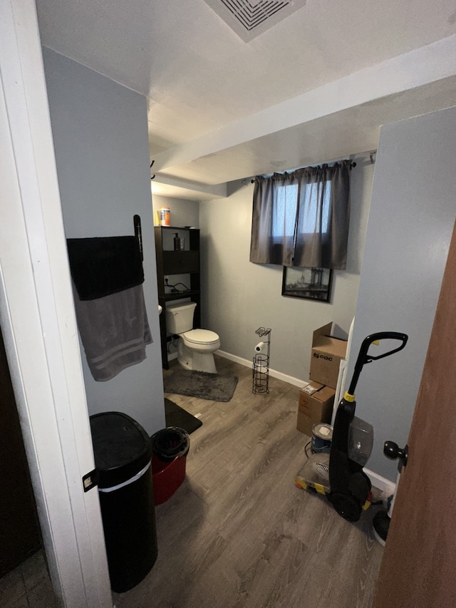 bathroom featuring visible vents, toilet, baseboards, and wood finished floors