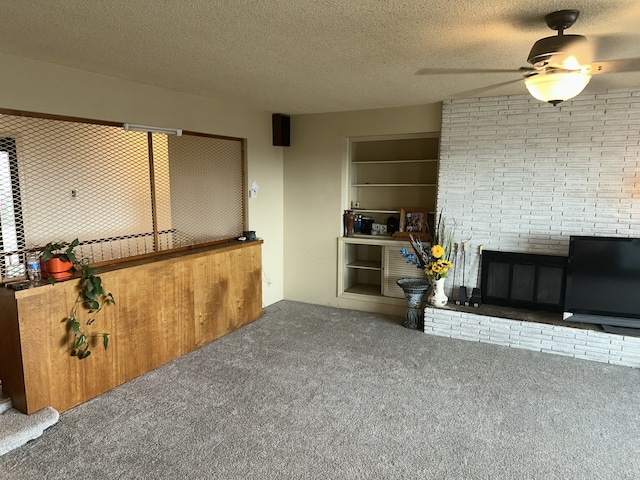 living room with a fireplace, ceiling fan, carpet, and a textured ceiling