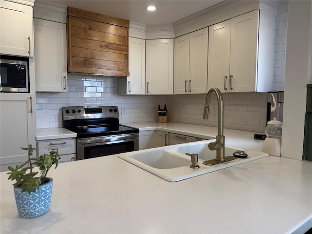 kitchen featuring tasteful backsplash, premium range hood, light countertops, appliances with stainless steel finishes, and white cabinets