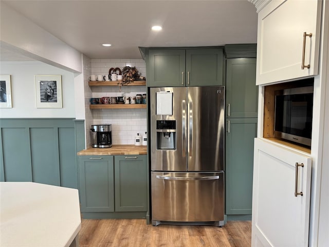 kitchen featuring stainless steel appliances, green cabinets, butcher block counters, and light wood-style flooring