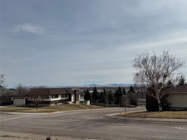 view of street featuring curbs, a mountain view, and sidewalks