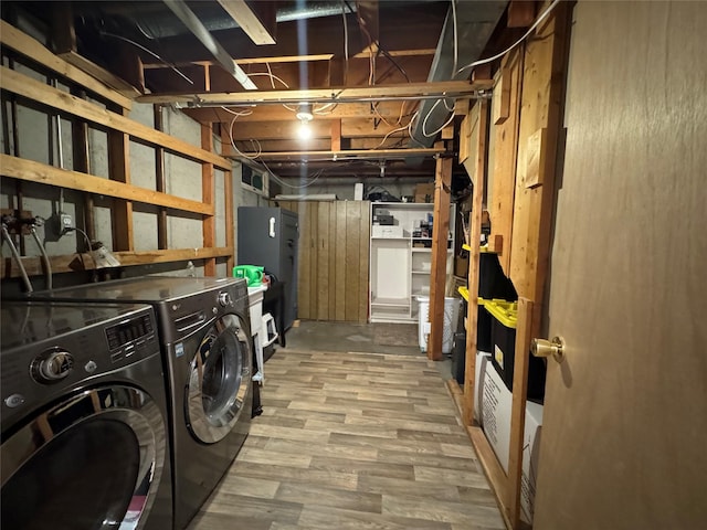 laundry area featuring laundry area, washing machine and dryer, and wood finished floors