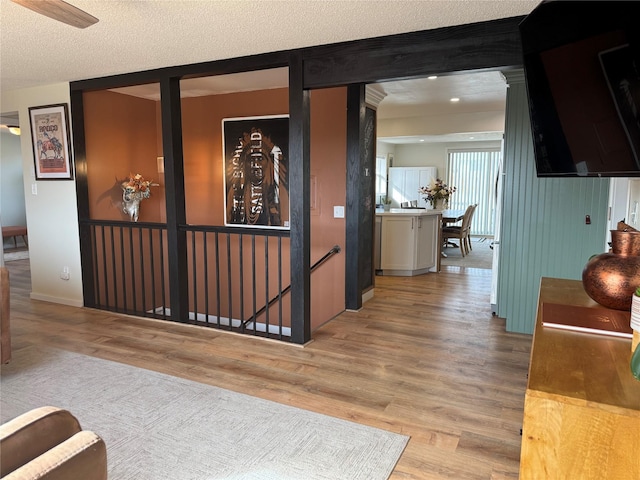 corridor featuring wood finished floors and a textured ceiling